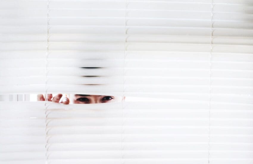 Person peeking through curtains